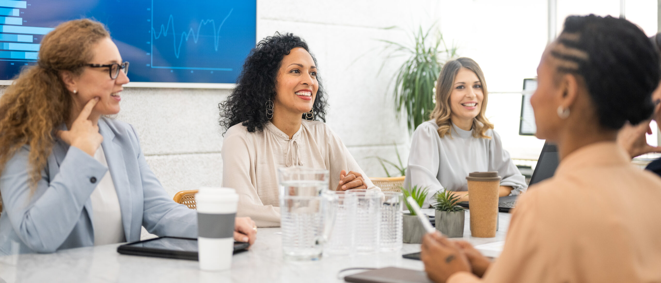 Businesswomen discussing while sitting in boardroom in office.
