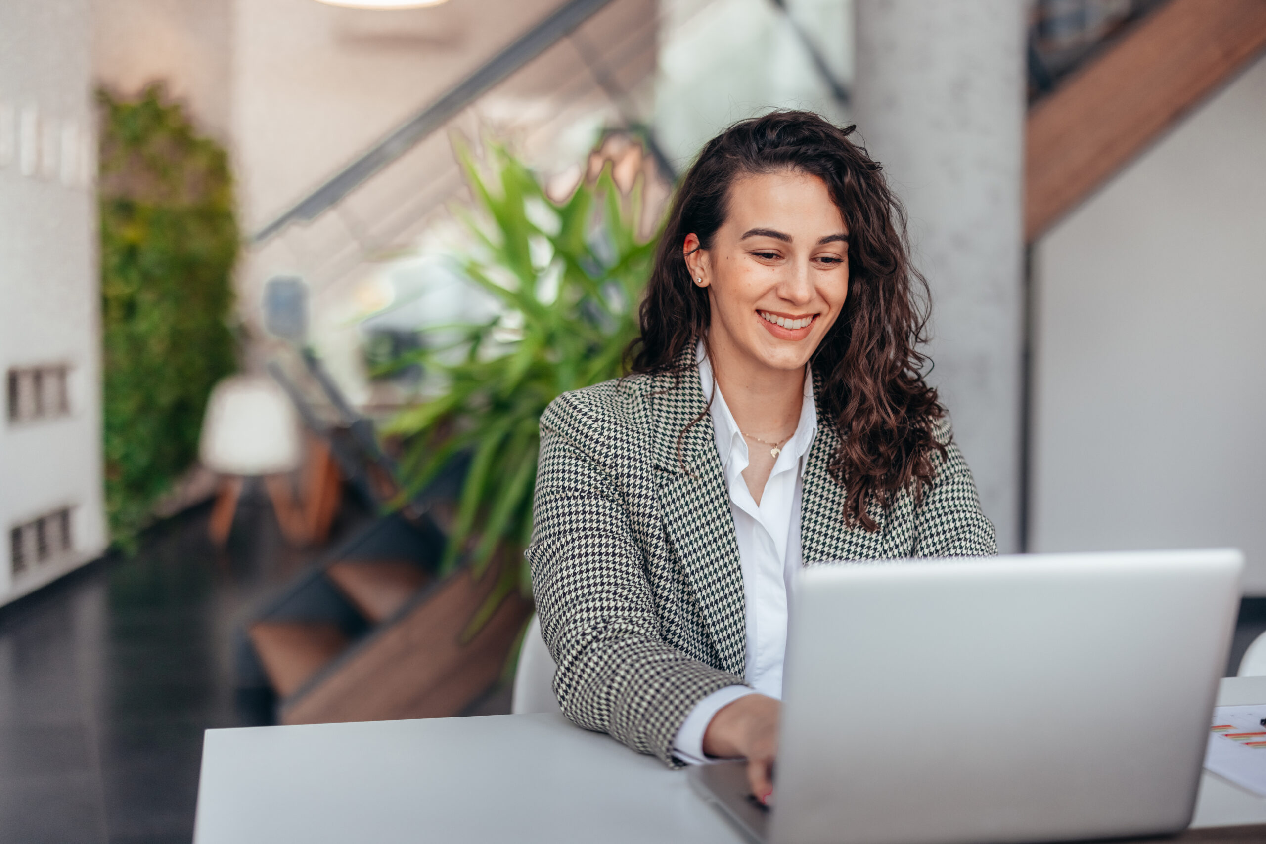 Successful businesswoman using laptop, working in office.